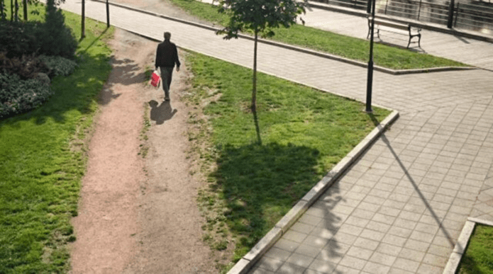 Man taking shortcut through a park